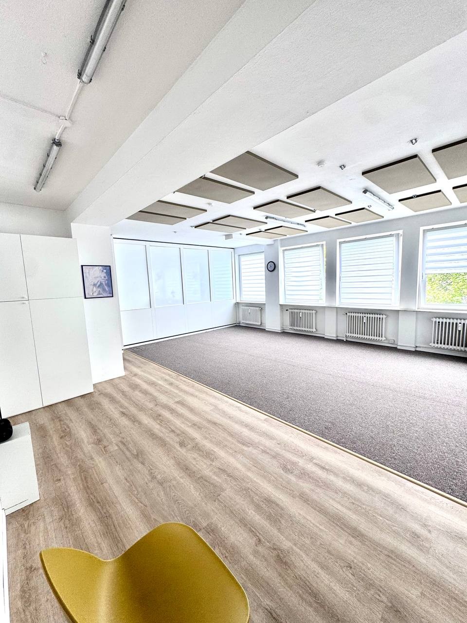 Großer Saal mit Teppich und hellen Fenstern