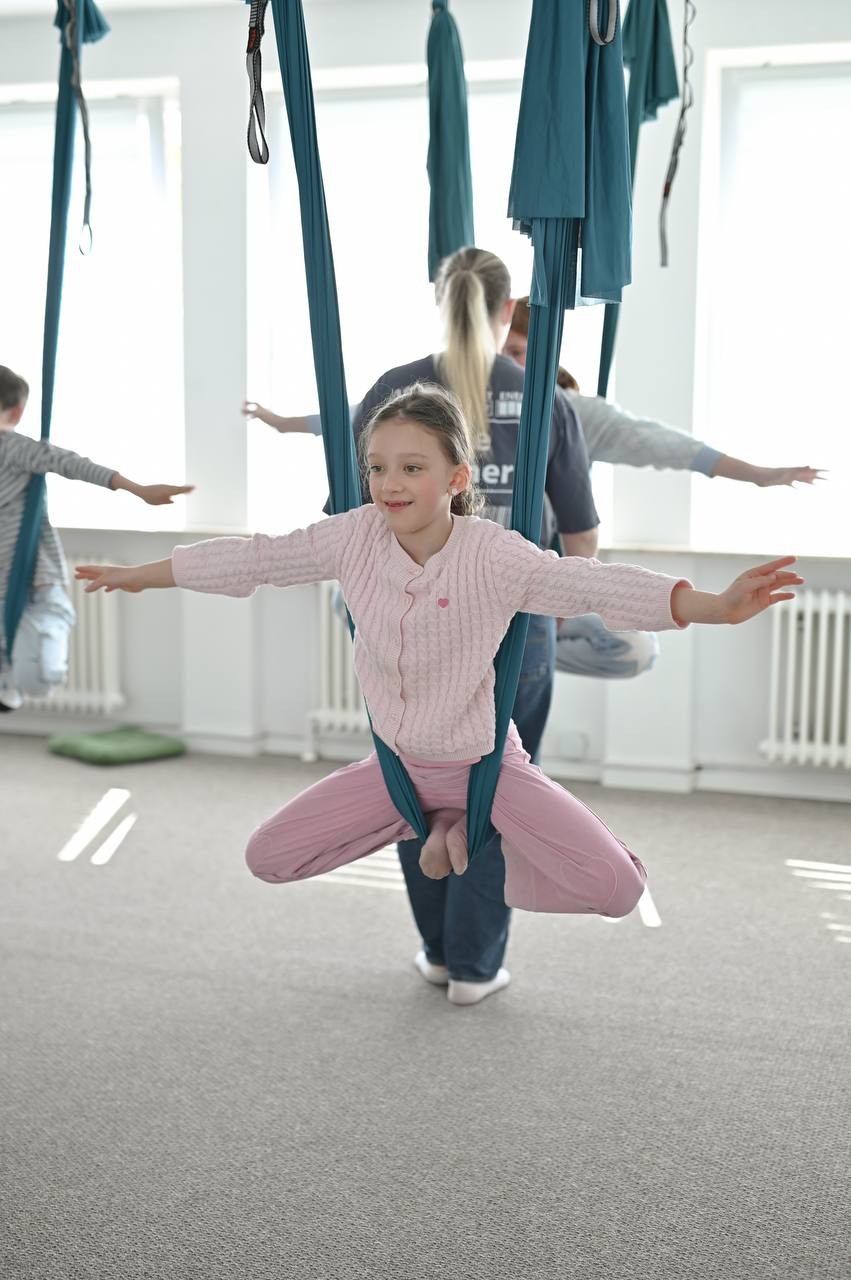 Mädchen balanciert im Fly-Yoga-Tuch